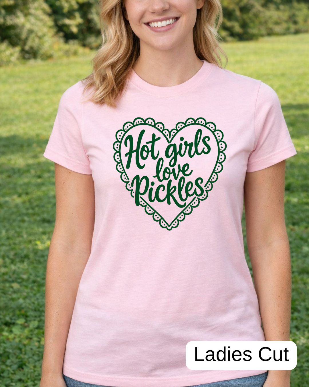 Woman wearing a pink t-shirt with 'Hot girls love pickles' design outdoors.