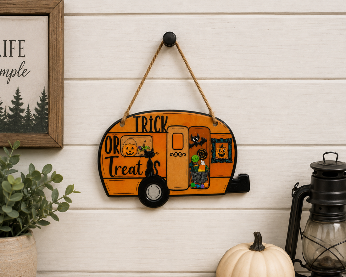 Halloween Trick or Treat Camper Door Hanger displayed on a shiplap wall with pumpkins and lantern