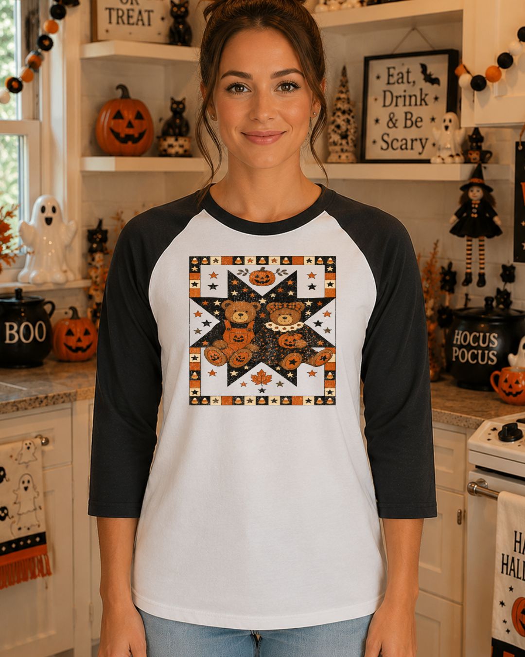 Woman wearing a white and black raglan baseball tee with a vintage patchwork quilt-style Halloween graphic featuring two teddy bears holding jack-o-lanterns surrounded by stars and candy corn