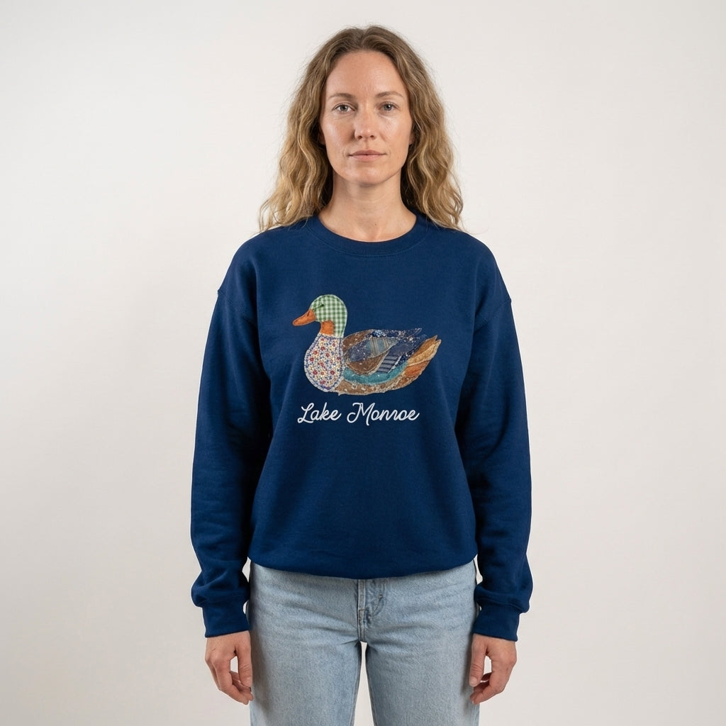 Person wearing a navy blue sweatshirt with a duck graphic and 'Lake Monroe' text on a plain background